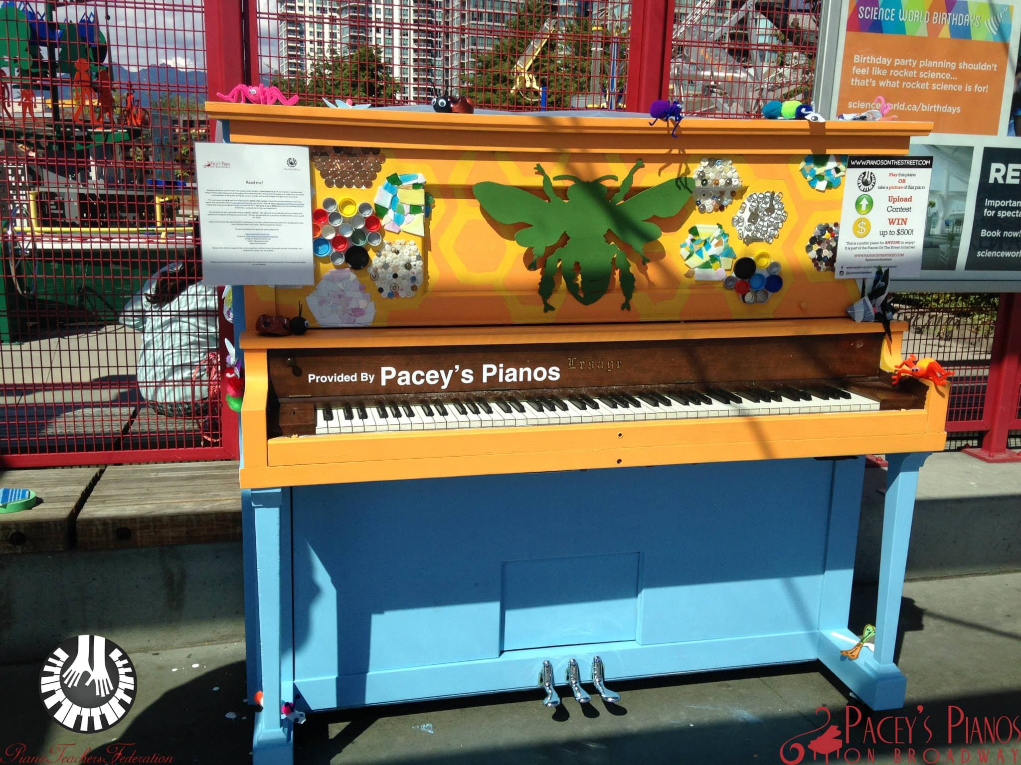 A honeycomb piano with a giant green bee, collaged with bottle caps and sea glass, at the Science World playground.