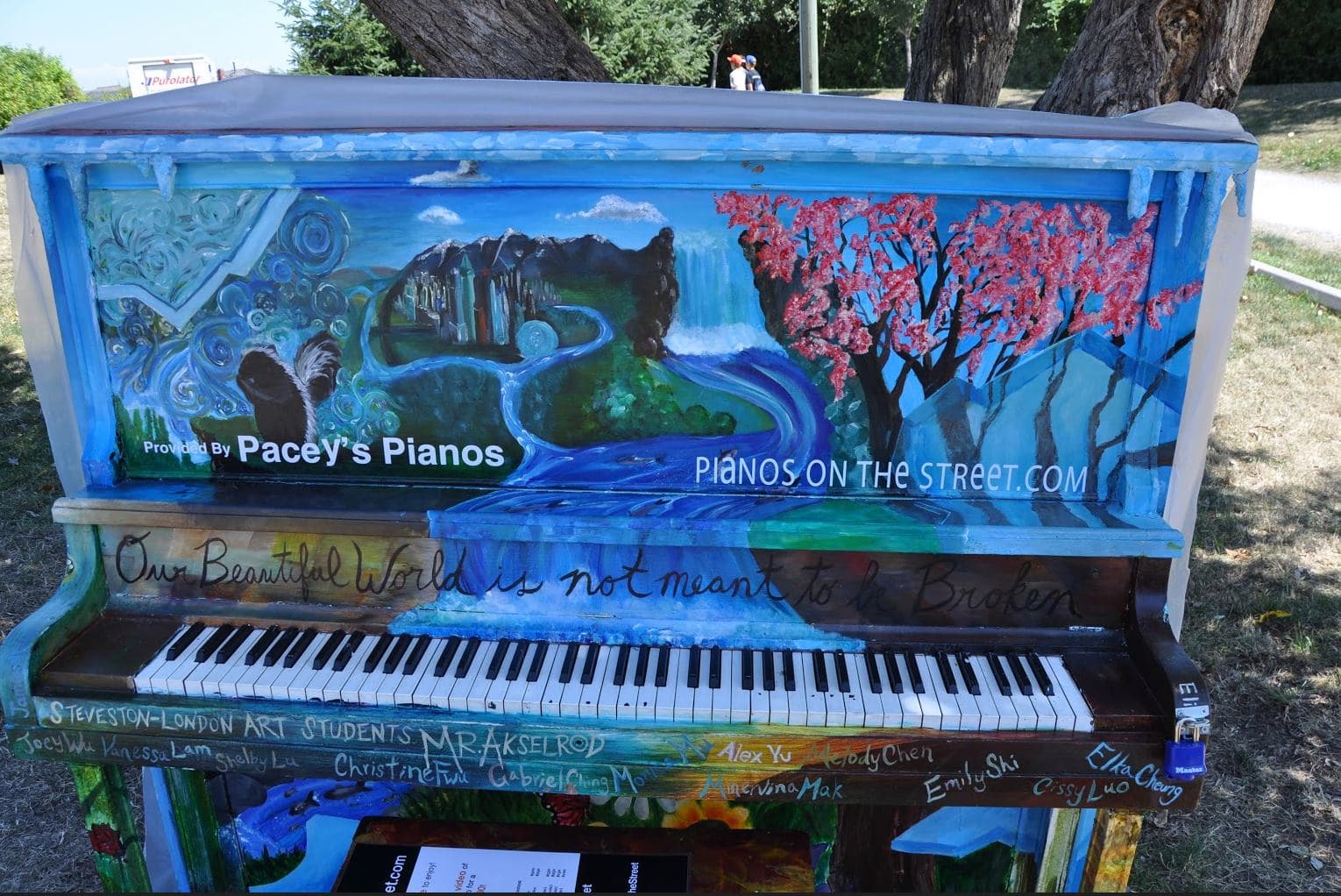 Student-painted panels of waterfalls, cherry blossoms and a crystal city, with every artist's name signed along the key rail.