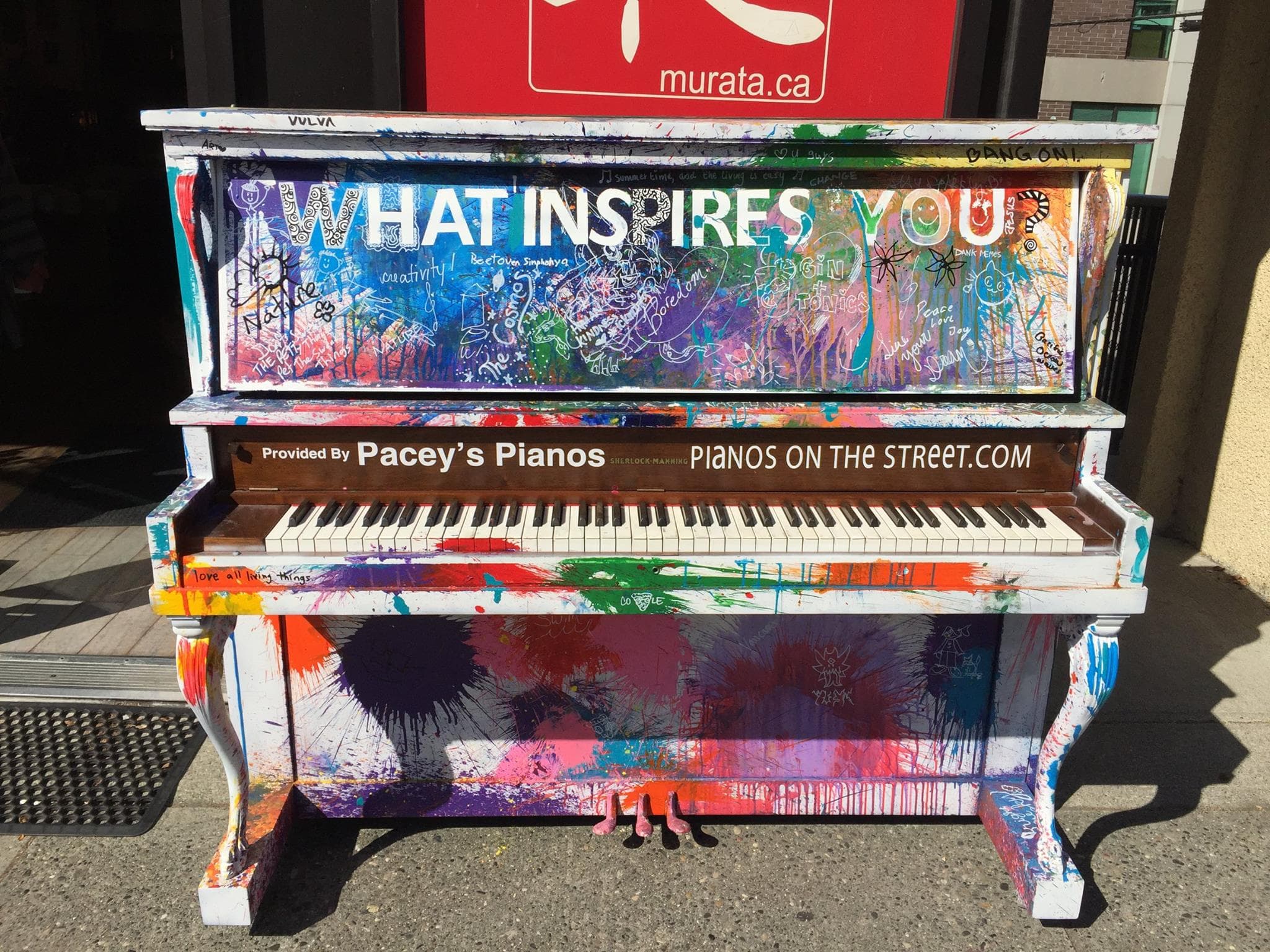 A splatter-painted upright asks WHAT INSPIRES YOU? in big white letters, covered in handwritten answers.